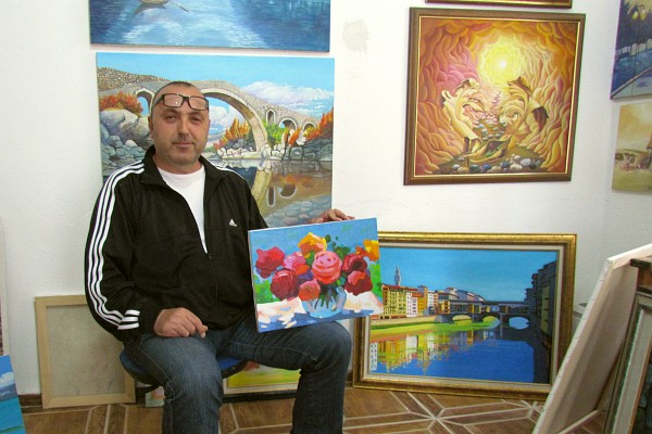 Rafael Cukaj with some of his paontings