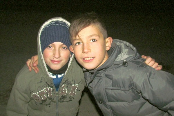two boys wanting their picture taken at night