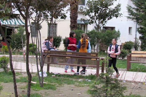 girls gather around a park bench neqar our apartment 