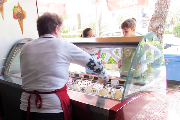 ice cream is being served from a small ice cream parlor