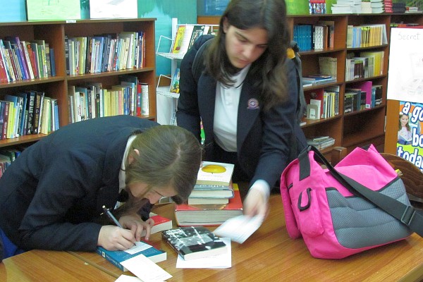 two students check out books for the reading contest