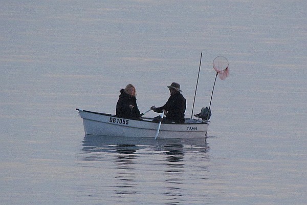 two persons fishing in a small boat