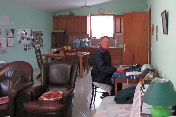 Allen at work on his computer in his kitchen-living room