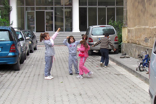 children at play in an alley to an apartment building