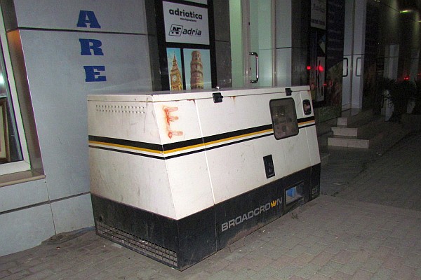 diesel generator on the sidewalk outside a store 