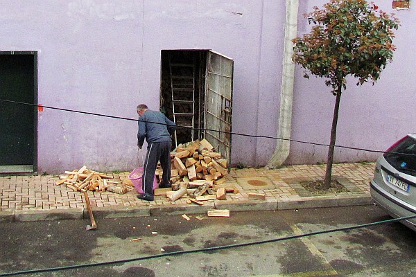a neighbor chops wood for his stove on fourth floor