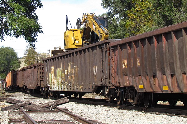 low-sdied gondola car with back-hoe for unloading