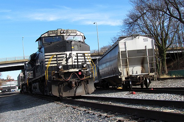 NS 7602 next to covered gondola cars