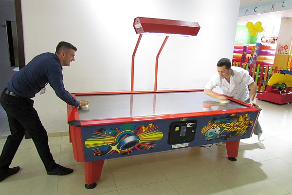 two men on break from the shops at the Net Center play air hockiey