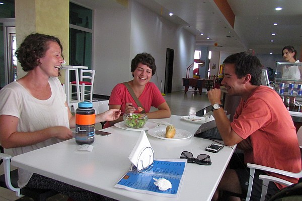 three volunteers from World Race eat a meal in Net Center