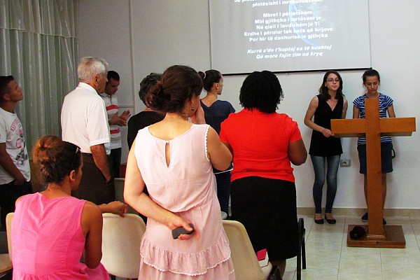 congregation stands to sing (left)