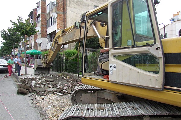 an excavator at work on a new street in Lezhe