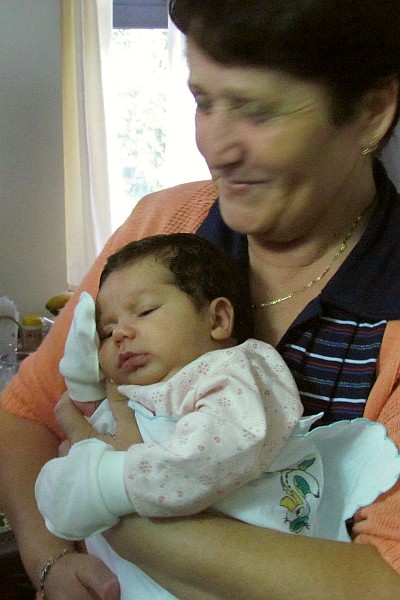 baby Mia held by her father's mothers