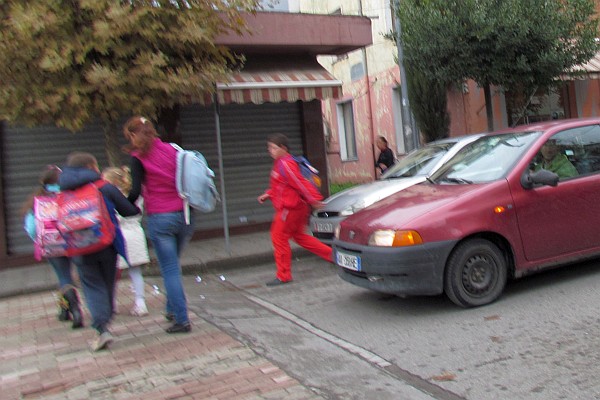 children rush across the street before cars start to move again