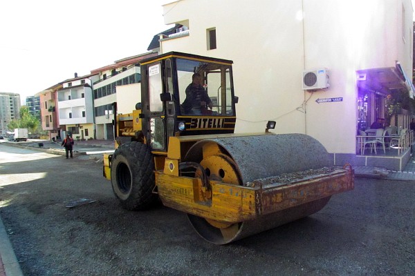 a roller compacting the gravel for the base of the new asphalt