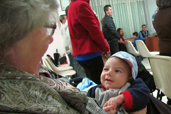Elsie holds baby Mateo in church