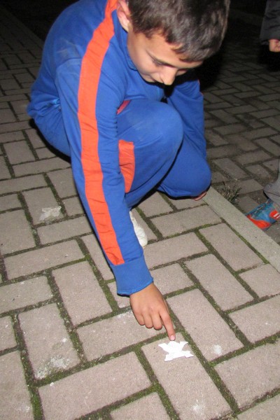 a boy deminstrates hixs origami frog can hop