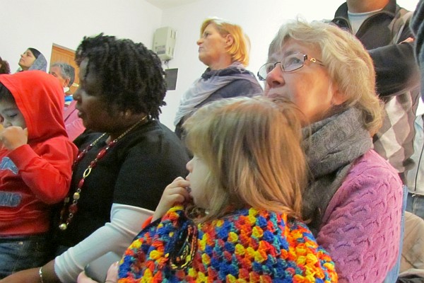 Norma holds Paulo & Elsie holds Sofia while singing in church