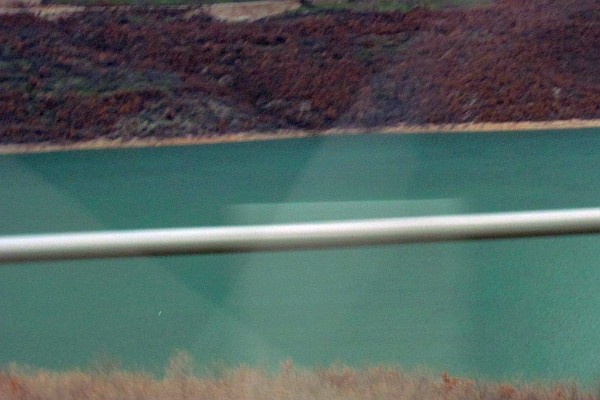 the greenish blue of a copper compound has tinted the lake
