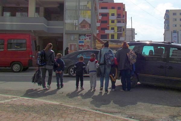 mothers walk their children home from school