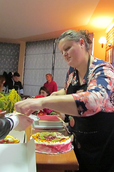 Mirela serves Edona's birthday cake to staff and teachers