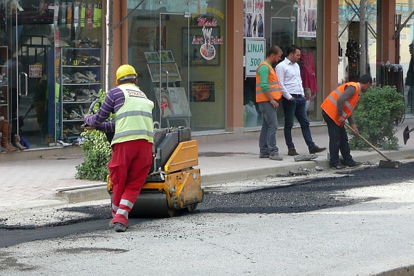 patching asphalt over the cuts for the new water mains