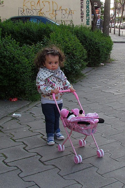a young girl catchees our interest on the sidewalk