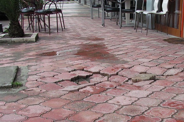 a sink hole of some kind under a sidewalk
