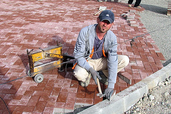 mason putting down blocks for a new portion of sidewalk