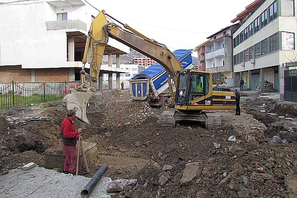 backhoe working on packing the substructure for the new street
