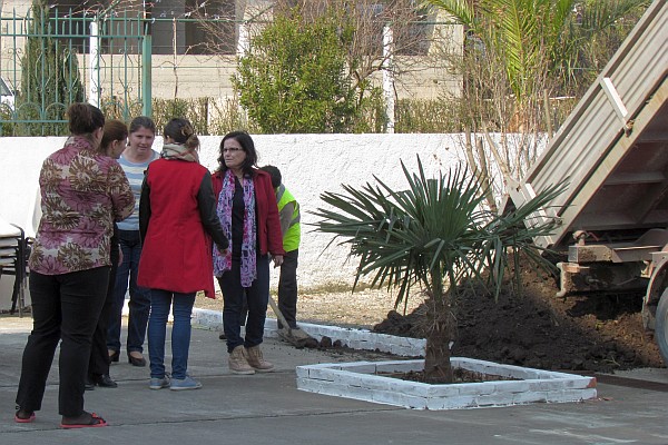 several women on the LAC staff watch at a truck dumps dirt at LAC