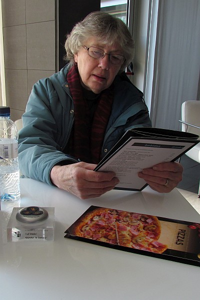 Elsie reads menu at hotel cafe