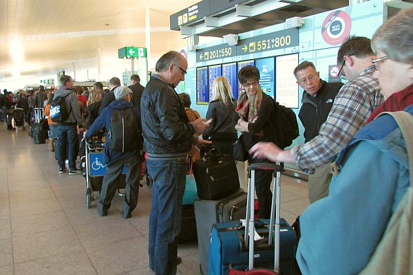 a long line wating to check luggage and get boarding pass for trip home