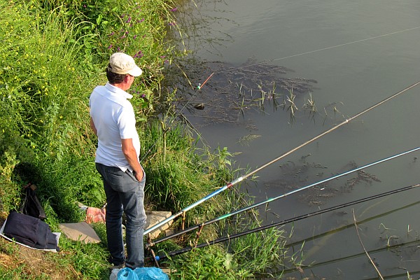 a fisherman along the Drini River at the bridge