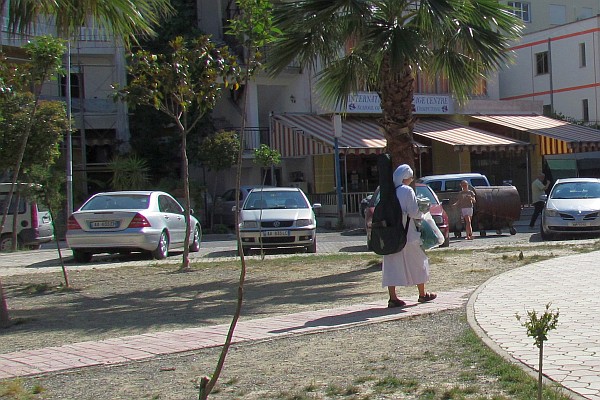 a num walking with her guitar to the ctholic worship service