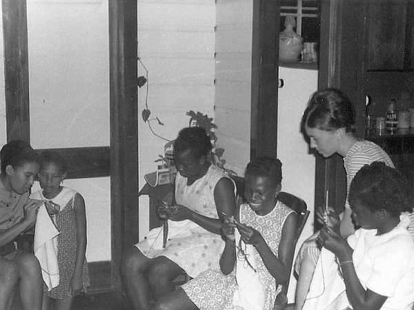 Betty and Elsie teach girls club to sow.
