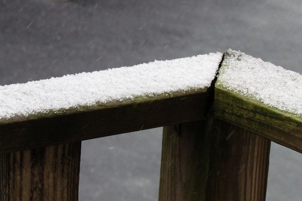 snow on a porch railing