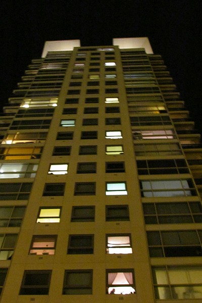 a high-rise at night next to the Diagonal Mar mall
