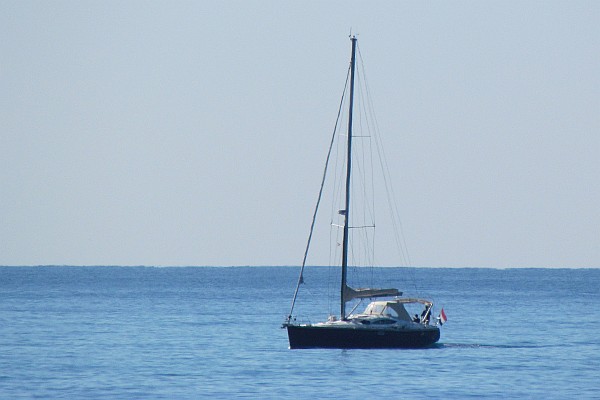 a sail boad mootoring along the shore