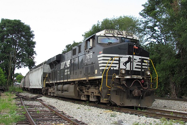 NS 7672 connected to a train of grain cars