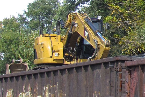 back-hoe unloading low-sdied gondola car