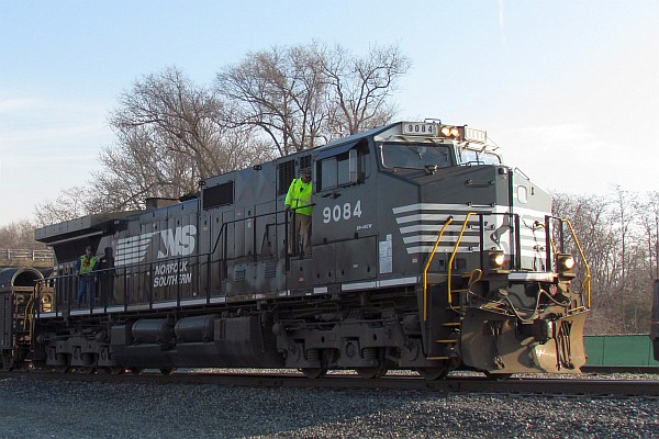 Men working with NS 9084 locomotive to make a train