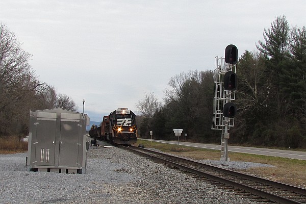 MoW train approaches railroad crossing